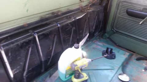 Interior view of a vehicle's cargo area with a fuel tank and a drill