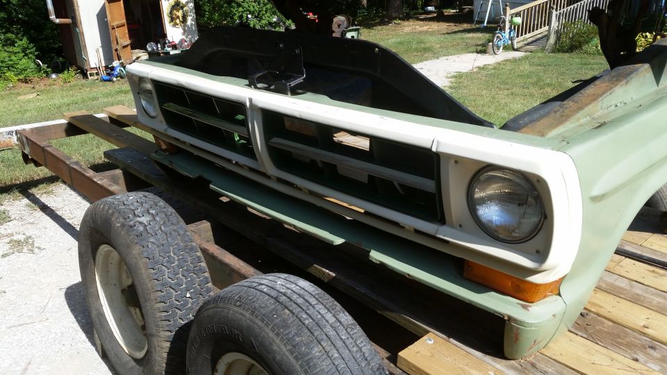 Light green 1970s Ford truck front clip with white grille surround and round headlight