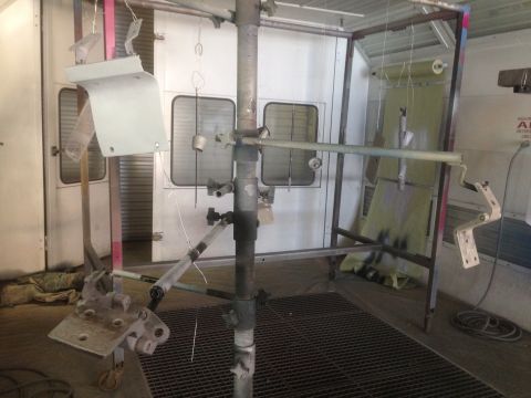 1964 Ford Fairlane - Various metal components are suspended for painting inside a spray booth.