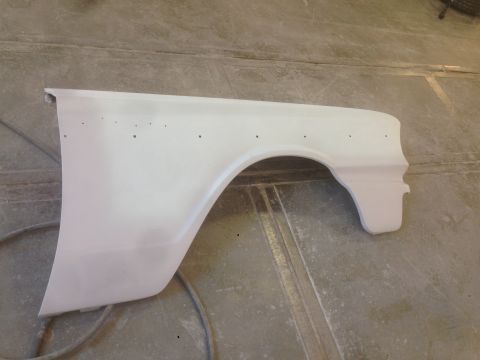 1964 Ford Fairlane - A white car fender, primed and ready for paint, is displayed on a concrete floor.