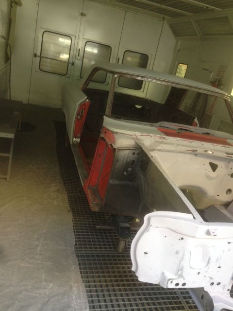 1964 Ford Fairlane - A 1964 Ford Fairlane body is being prepped for paint inside a booth, booth, showing its interior and front end.