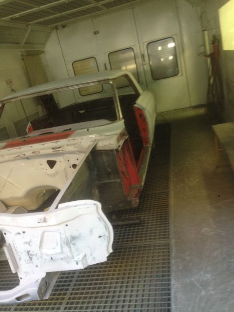 1964 Ford Fairlane - A car body is undergoing restoration work inside a spray booth.
