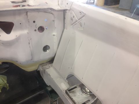 1964 Ford Fairlane - Close-up view of the unpainted inner fender and frame structure of a car undergoing restoration.