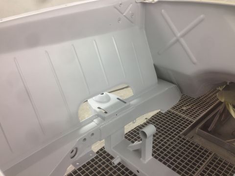 1964 Ford Fairlane - The interior of a car chassis, likely undergoing restoration or preparation, is shown with a fresh coat of white paint.