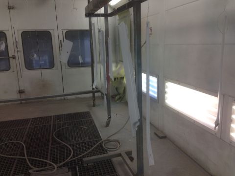 1964 Ford Fairlane - Parts are suspended in a paint booth, awaiting their coating.