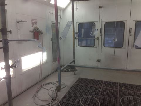 1964 Ford Fairlane - Interior view of a paint booth, equipped with spray guns, hoses, and ventilation systems.
