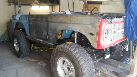 1979 Ford Bronco - This 1979 Ford Bronco appears to be undergoing significant bodywork and modification, evident from its rusted panels and lifted suspension.