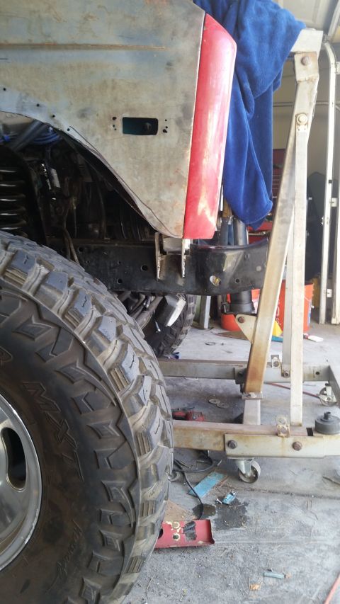 1979 Ford Bronco - A vehicle is in a workshop, with its fender and large tire in the foreground, suggesting ongoing maintenance or restoration.
