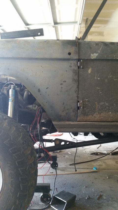 1979 Ford Bronco - This unfinished vehicle shows its side profile, with exposed wiring and suspension parts visible beneath the body panels.