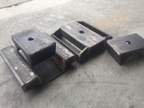 1979 Ford Bronco - Several custom-fabricated steel suspension components are laid out on a concrete surface.