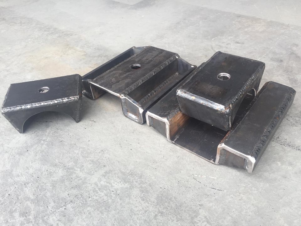 Several metal blocks with holes, likely for vehicle suspension lift