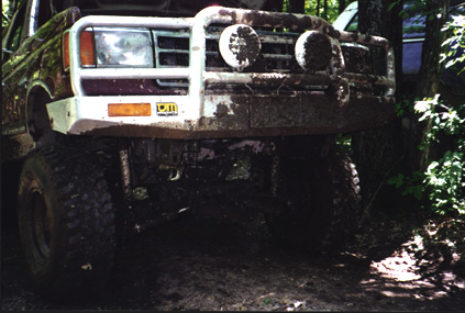 1991 Ford Bronco - This heavily muddied truck is equipped with a brush guard and large off-road tires, suggesting it's used for off-roading.