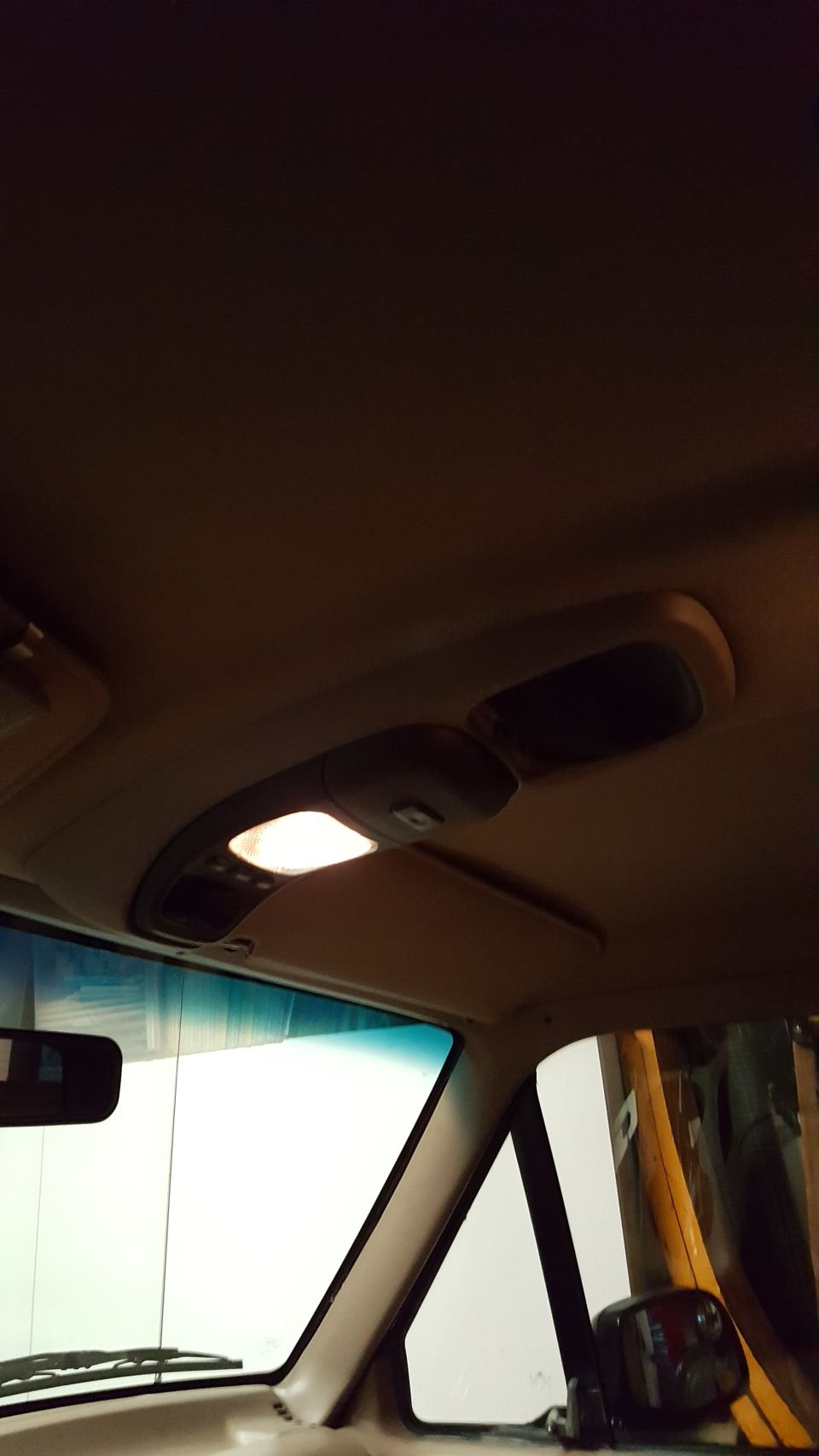 Interior overhead console with illuminated light and storage compartments