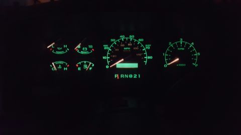 1996 Ford Bronco - The illuminated dashboard gauges of a 1996 Ford Bronco are visible in the dark.