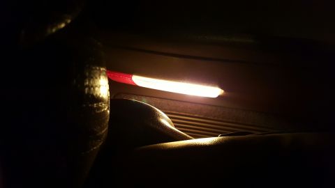 1996 Ford Bronco - A close-up view of an illuminated interior light strip with red and white sections.