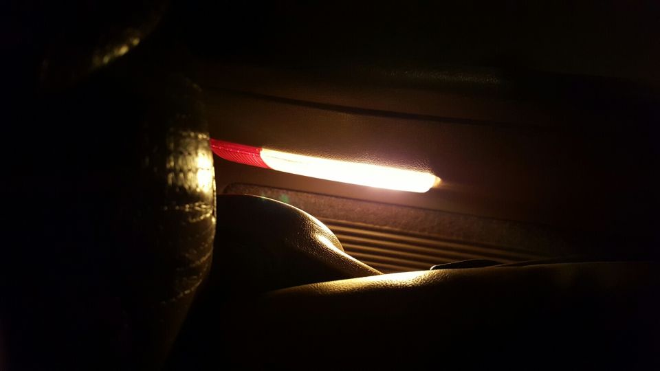 interior light strip with red and white sections, above ribbed paneling