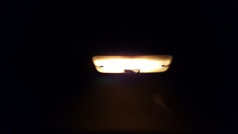 1996 Ford Bronco - The interior dome light is on, casting a warm glow in the dark cabin.