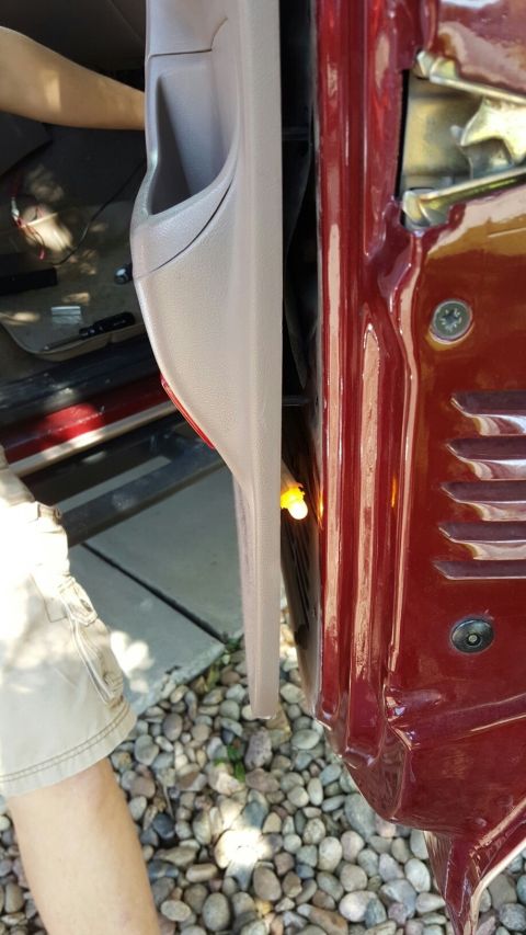 1996 Ford Bronco - A small yellow light is visible in the door jamb of a red vehicle.