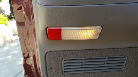 1996 Ford Bronco - Close-up of a vehicle's interior door panel, highlighting a light and air vent.