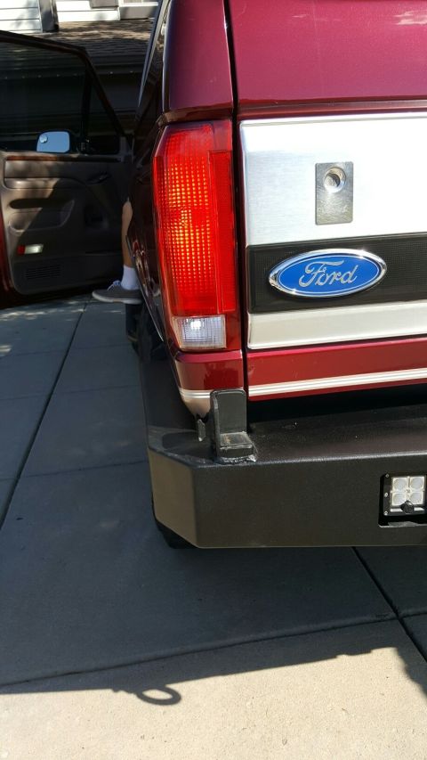 1996 Ford Bronco - Rear view of a red 1996 Ford Bronco, a custom bumper with integrated LED lights and the iconic Ford badge.
