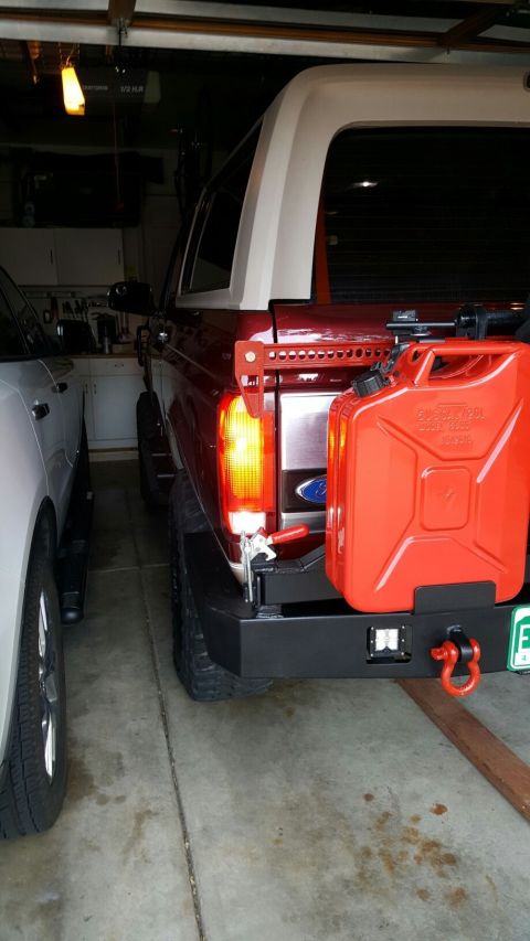 1996 Ford Bronco - Rear view of a red 1996 Ford Bronco parked in a garage next to another vehicle.