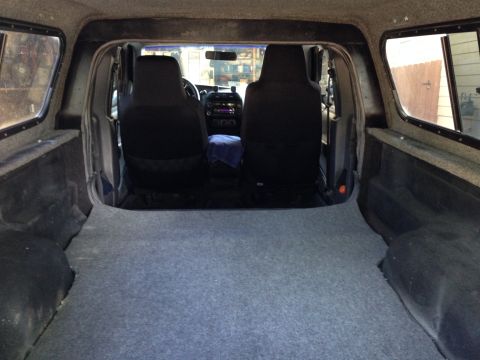 2001 Ford Ranger - View from the bed of a pickup truck, looking towards the cab and camper shell interior.