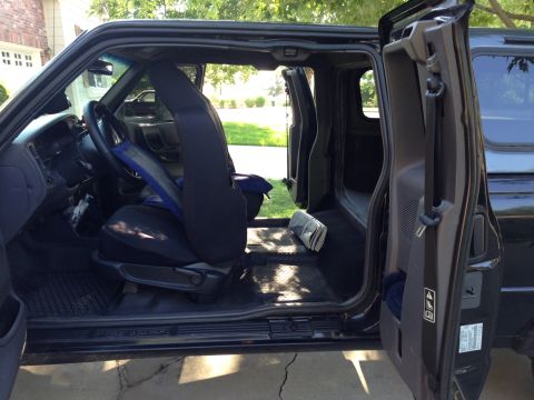 2001 Ford Ranger - The interior of a pickup truck is shown with both front doors open, revealing the seats and floor.