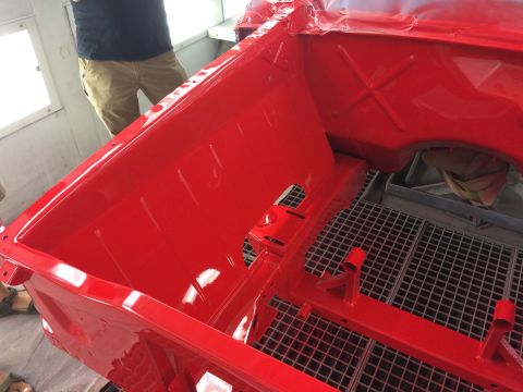1964 Ford Fairlane - The interior of a red car is shown, possibly undergoing restoration or painting, with a metal grate floor.