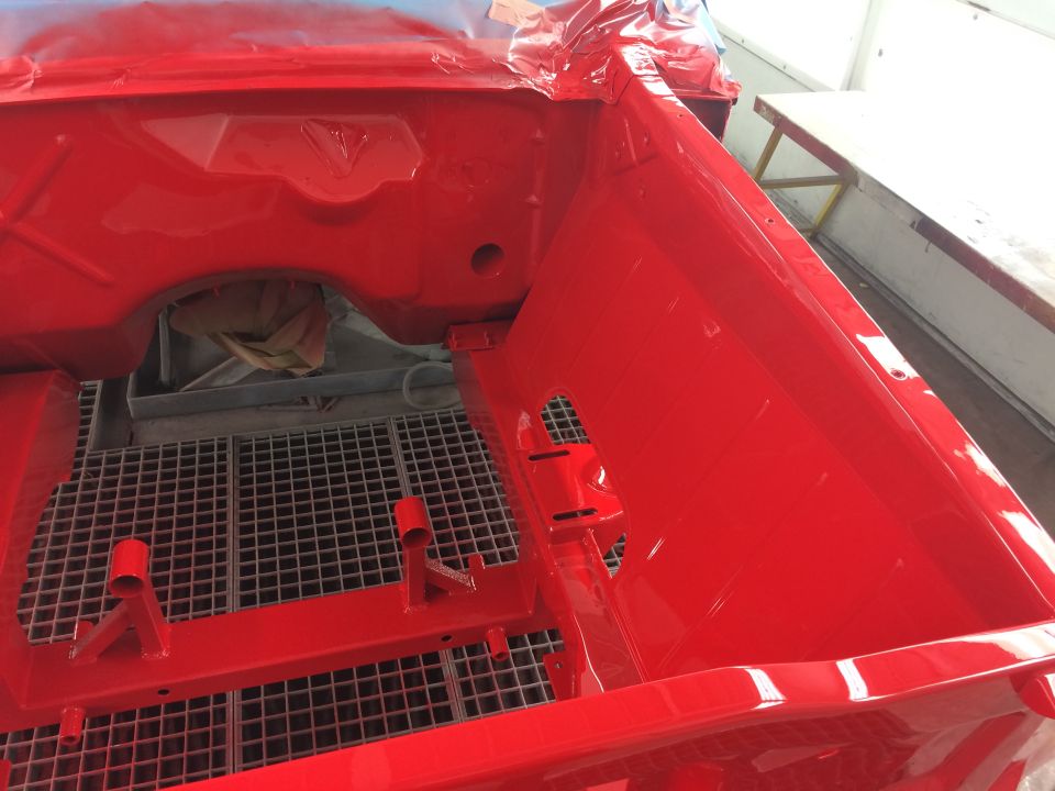 red painted car body interior with metal grate floor