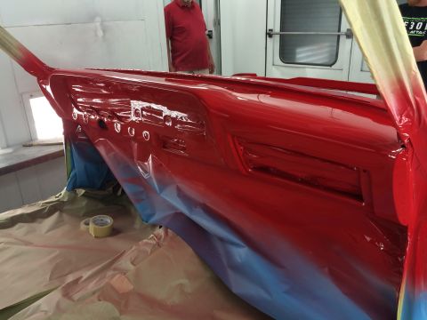 1964 Ford Fairlane - A freshly painted red dashboard is being prepped for reinstallation in a paint booth.