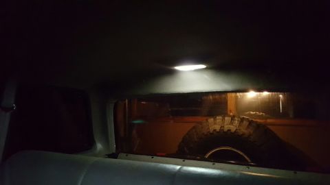 1996 Ford Bronco - The interior of a vehicle shows a spare tire and a ceiling light illuminating the space.