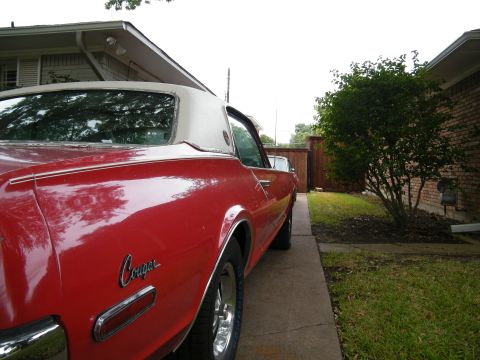 1968 Mercury Cougar - Rear quarter view of a red 1968 Mercury Cougar with a white vinyl top parked in a driveway.