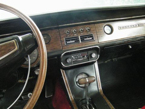 1968 Mercury Cougar - The interior dashboard features wood grain trim, a center console, and prominent "COUGAR XR7" badging, indicating a specific trim level.
