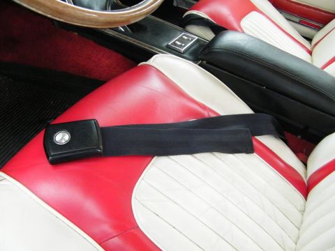 1968 Mercury Cougar - Close-up of a car's interior, focusing on the seatbelt and two-tone seats.