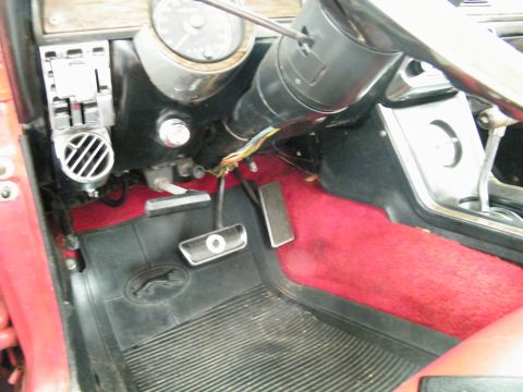 1968 Mercury Cougar - The interior of a 1968 Mercury Cougar shows red carpeting and a black floor mat with a jaguar emblem.