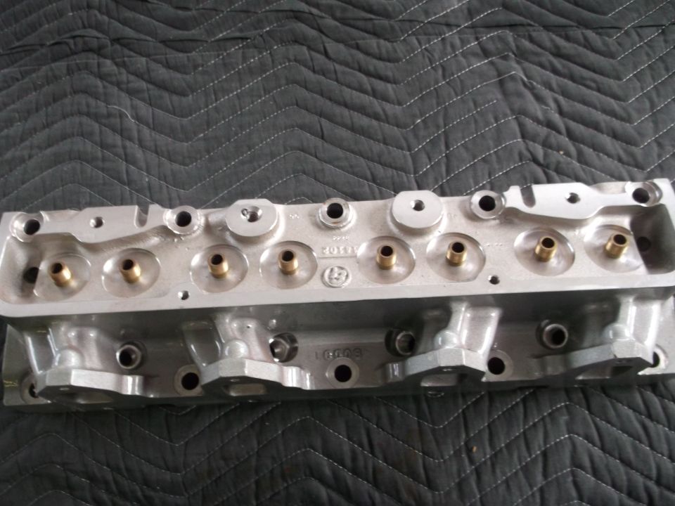 Aluminum engine cylinder head with brass inserts