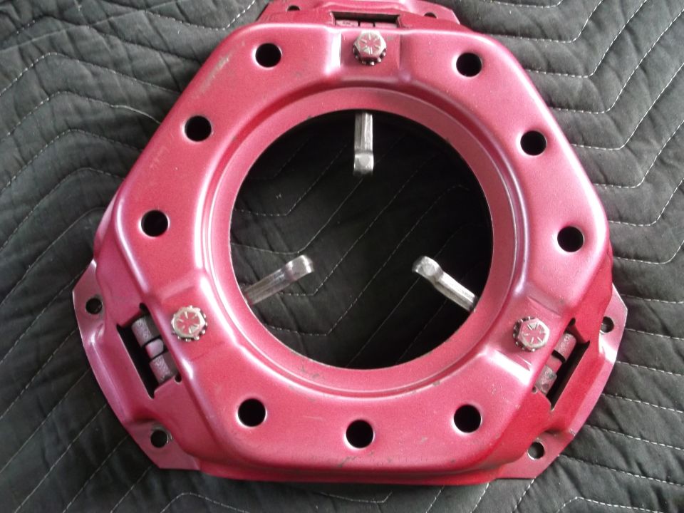 Red clutch pressure plate with three spring-loaded levers visible through the center opening
