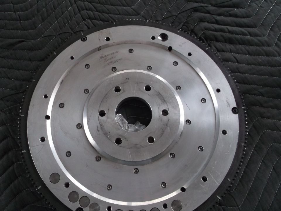 Metal flywheel with bolt holes and engraved text