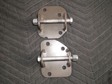 1971 Ford Ranchero - Two metal brackets with bolts and nuts are shown on a black quilted background.
