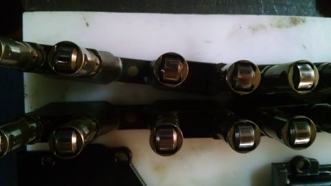 1985 Jeep CJ7 - Engine valve train rocker arms are laid out on a workbench for inspection or repair.