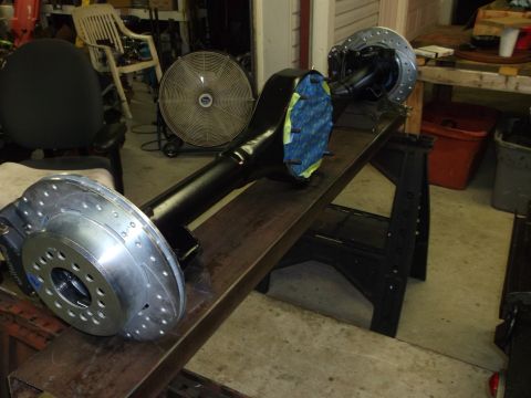 1967 Ford Mustang - A rear axle assembly with disc brakes is shown on sawhorses in a workshop setting.