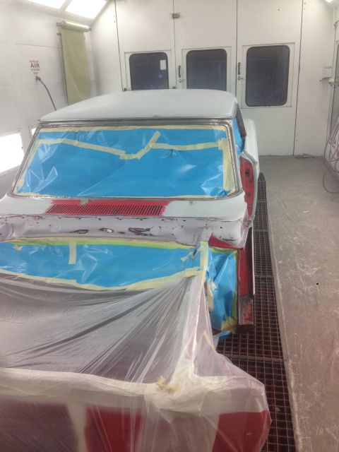 1964 Ford Fairlane - A 1964 Ford Fairlane is prepped for painting inside a booth, with windows and trim covered in blue masking tape.