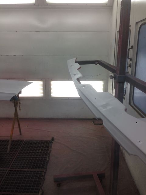 1964 Ford Fairlane - Car part being prepped for painting in a spray booth.