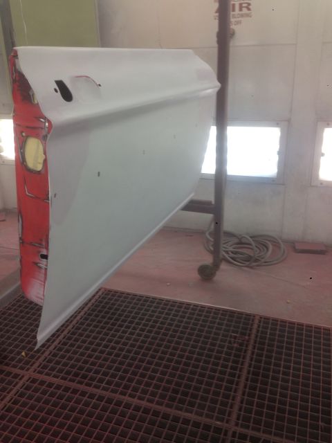 1964 Ford Fairlane - A car door is suspended in a paint booth, ready for its new coat of paint.
