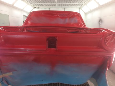 1964 Ford Fairlane - Rear view of a red 1964 Ford Fairlane undergoing painting in a booth.