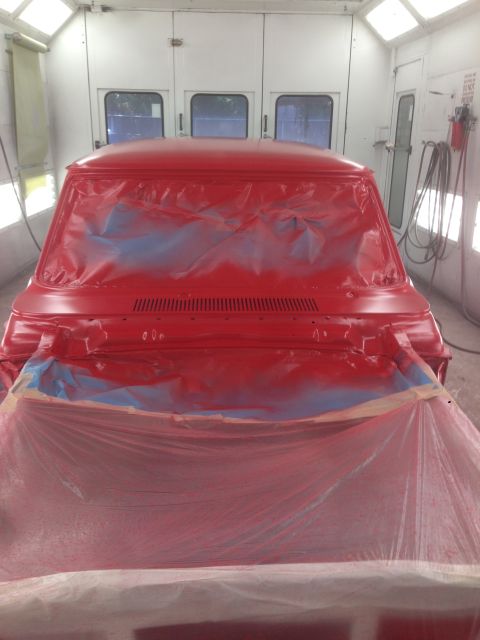 1964 Ford Fairlane - A red pickup truck is being prepped for paint in a professional spray booth.