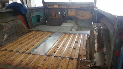 1979 Ford Bronco - The interior of a vehicle, likely a truck or SUV, shows extensive rust and repair work on the floor and rear cargo area.