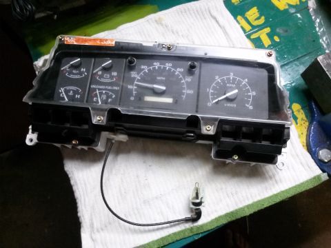 1996 Ford Bronco - Instrument cluster removed from a vehicle, showing gauges for speed, RPM, fuel, and temperature.