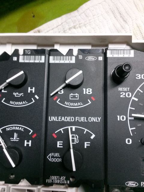 1996 Ford Bronco - Close-up of a car's instrument cluster gauges, including fuel level and battery status indicators.