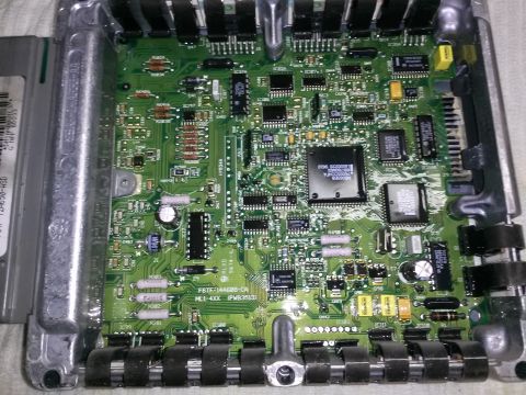 1996 Ford Bronco - Close-up of an engine control unit's internal circuit board, showing intricate electronic components.